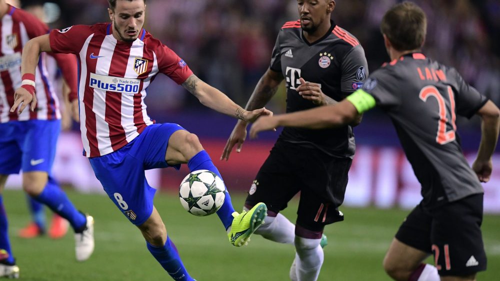 Atletico Madrid's midfielder Saul Niguez (L) vies with Bayern Munich's Brazilian midfielder Douglas Costa during the UEFA Champions League Group D football match Club Atletico de Madrid vs FC Bayern Munich at the Vicente Calderon stadium in Madrid on September 28, 2016. / AFP / JAVIER SORIANO