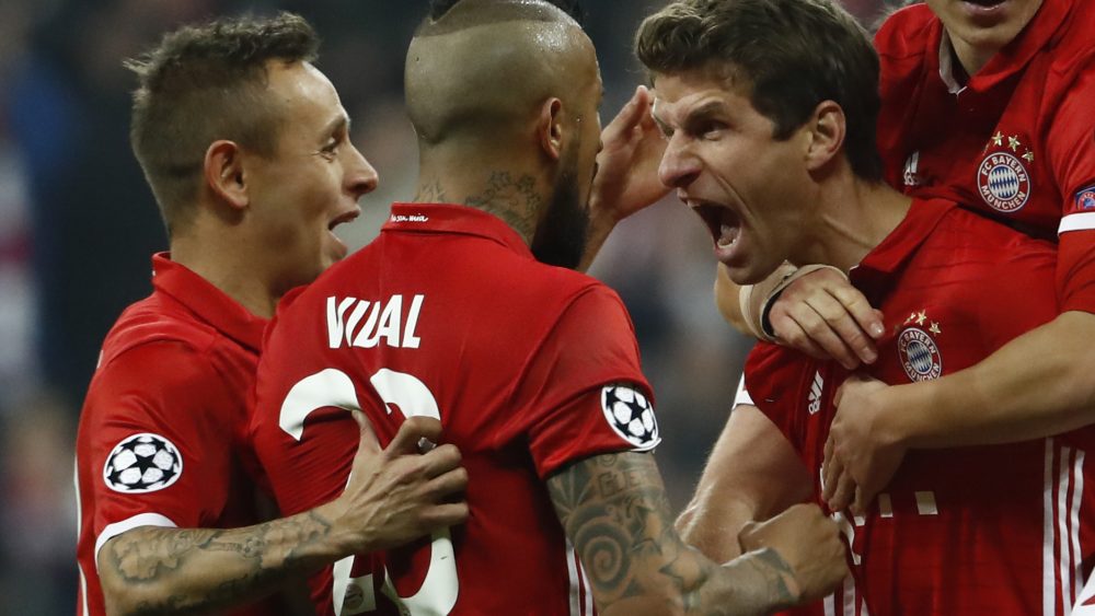 Bayern Munich's forward Thomas Mueller (R) celebrate scoring the 5-1 goal with his teammates during the UEFA Champions League round of sixteen football match between FC Bayern Munich and Arsenal in Munich, southern Germany, on February 15, 2017. / AFP / Odd ANDERSEN (Photo credit should read ODD ANDERSEN/AFP/Getty Images)
