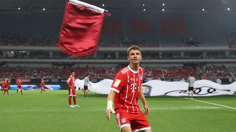 SHANGHAI, CHINA - JULY 19: Thomas Mueller of Bayern Muenchen throws the team pennant prior to the Audi Football Summit 2017 match between Bayern Muenchen and Arsenal FC at Shanghai Stadium during the Audi Summer Tour 2017 on July 19, 2017 in Shanghai, China. (Photo by Alexander Hassenstein/Bongarts/Getty Images)