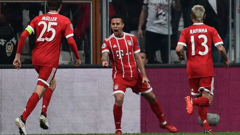 Bayern Munich's Spanish midfielder Thiago Alcantara (C) celebrates with teammates German forward Thomas Mueller (L) and Brazilian defender Rafinha (R) after scoring his team's first goal during the second leg of the last 16 UEFA Champions League football match between Besiktas and Bayern Munich at Besiktas Park in Istanbul on March 14, 2018. / AFP PHOTO / OZAN KOSE (Photo credit should read OZAN KOSE/AFP/Getty Images)