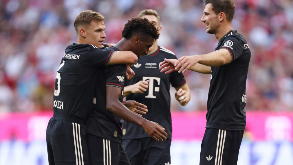 Kingsley Coman wird von seinen Teamkollegen beim FC Bayern umarmt und gefeiert.