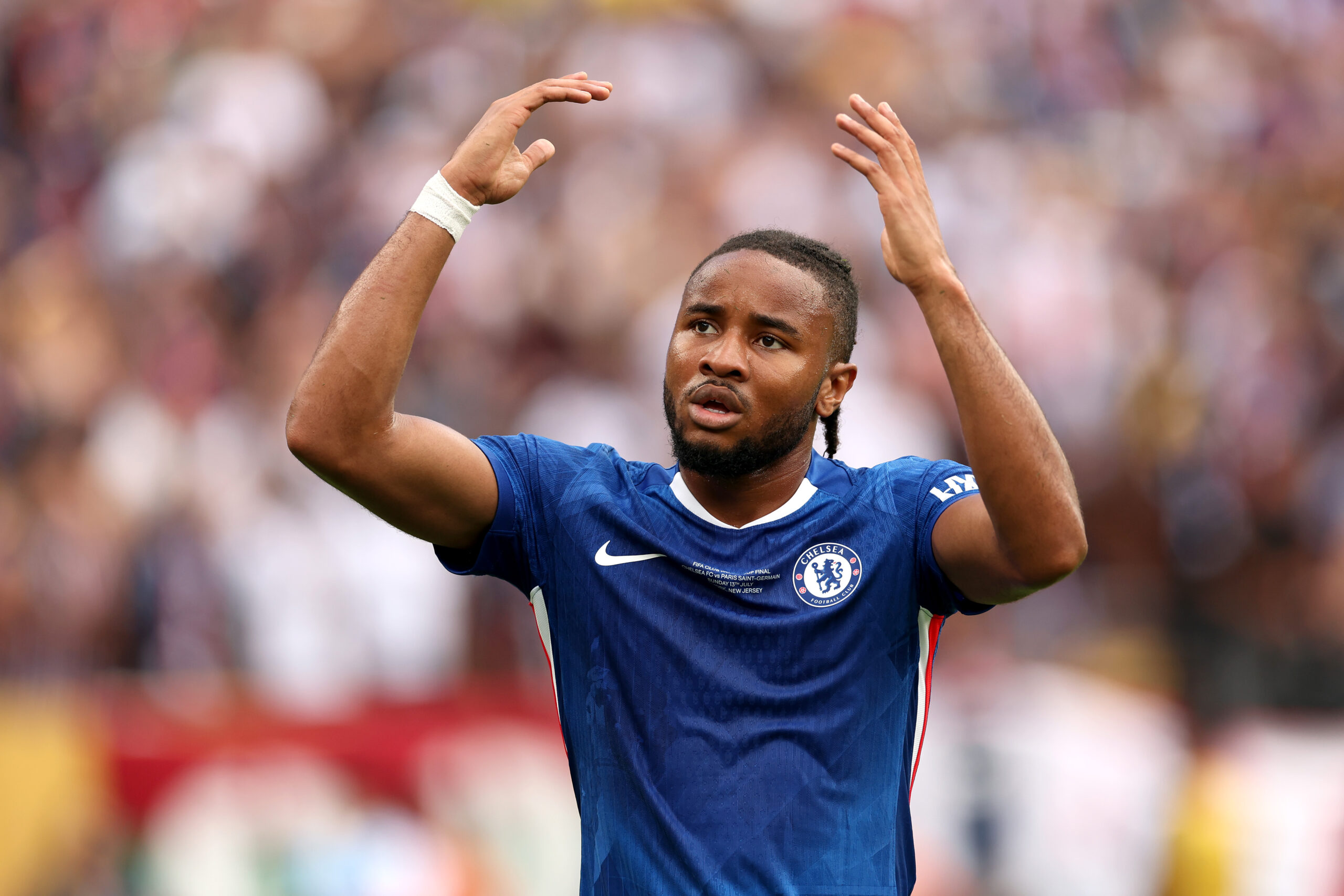 Christopher Nkunku im Trikot des FC Chelsea in blau, er reißt die Arme hoch. Im Hintergrund Publikum. Spielt Nkunku bald für den FC Bayern?