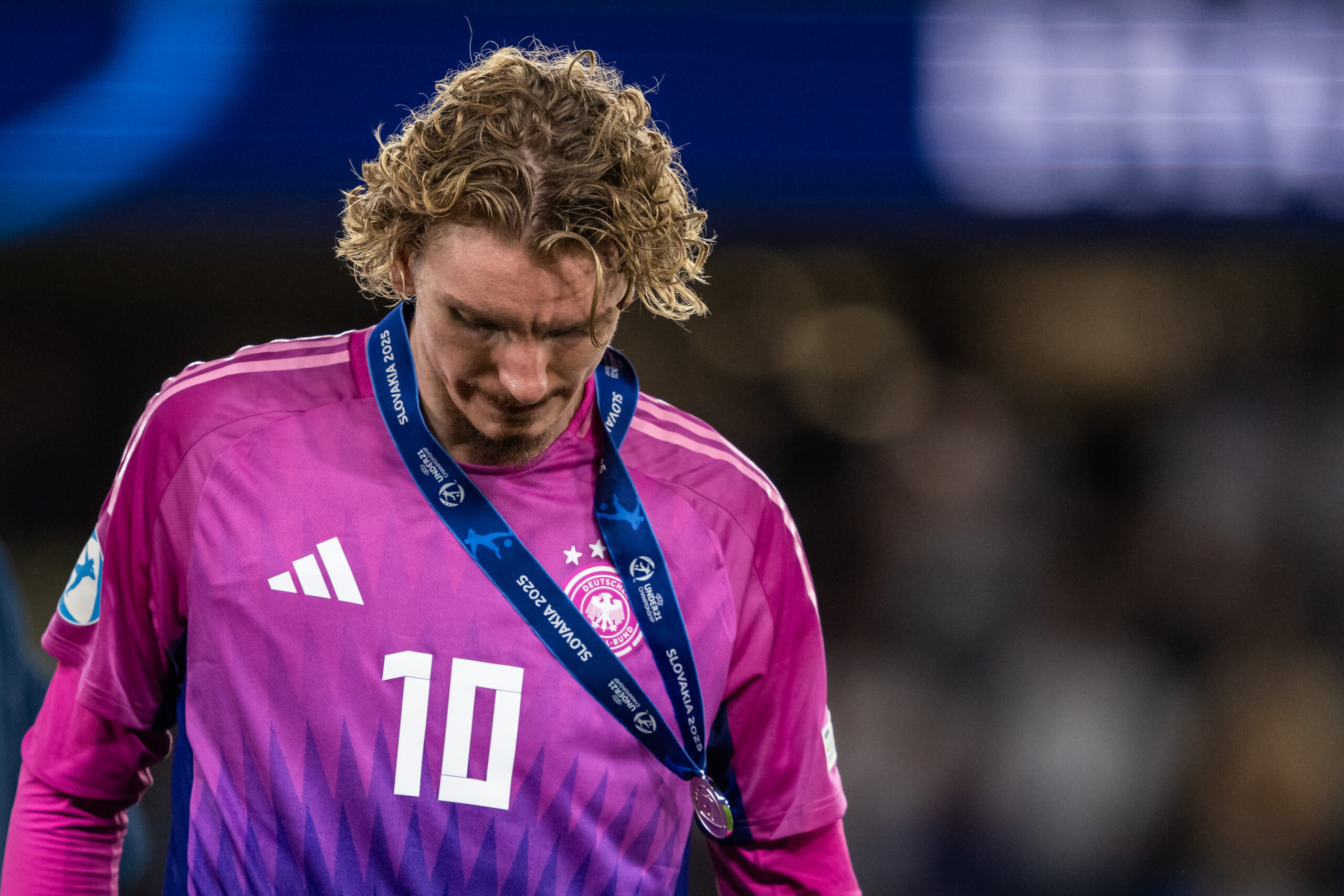 Nick Woltemade im Trikot des DFB-Teams (pink) und der Medaille von der U21-EM um den Hals. Er senkt den Kopf enttäuscht, weil er das Finale verlor. Aktuell wird ein Wechsel zum FC Bayern diskutiert.