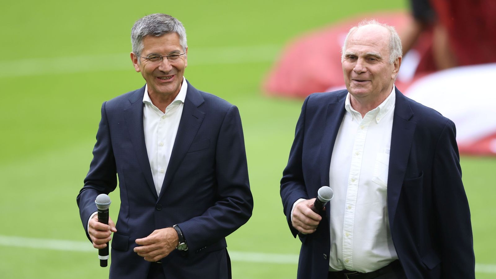 Herbert Hainer und Uli Hoeneß vom FC Bayern stehen nebeneinander. Im Hintergrund grüner Rasen.