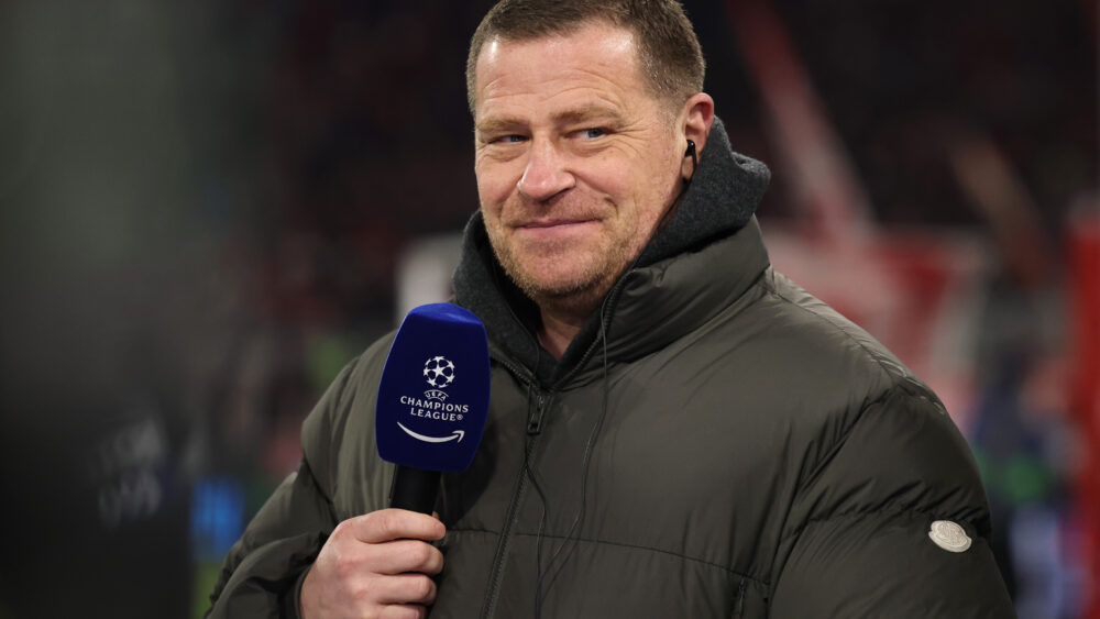 Max Eberl in Winterjacke am Champions-League-Mikrofon vor einem Spiel des FC Bayern München.