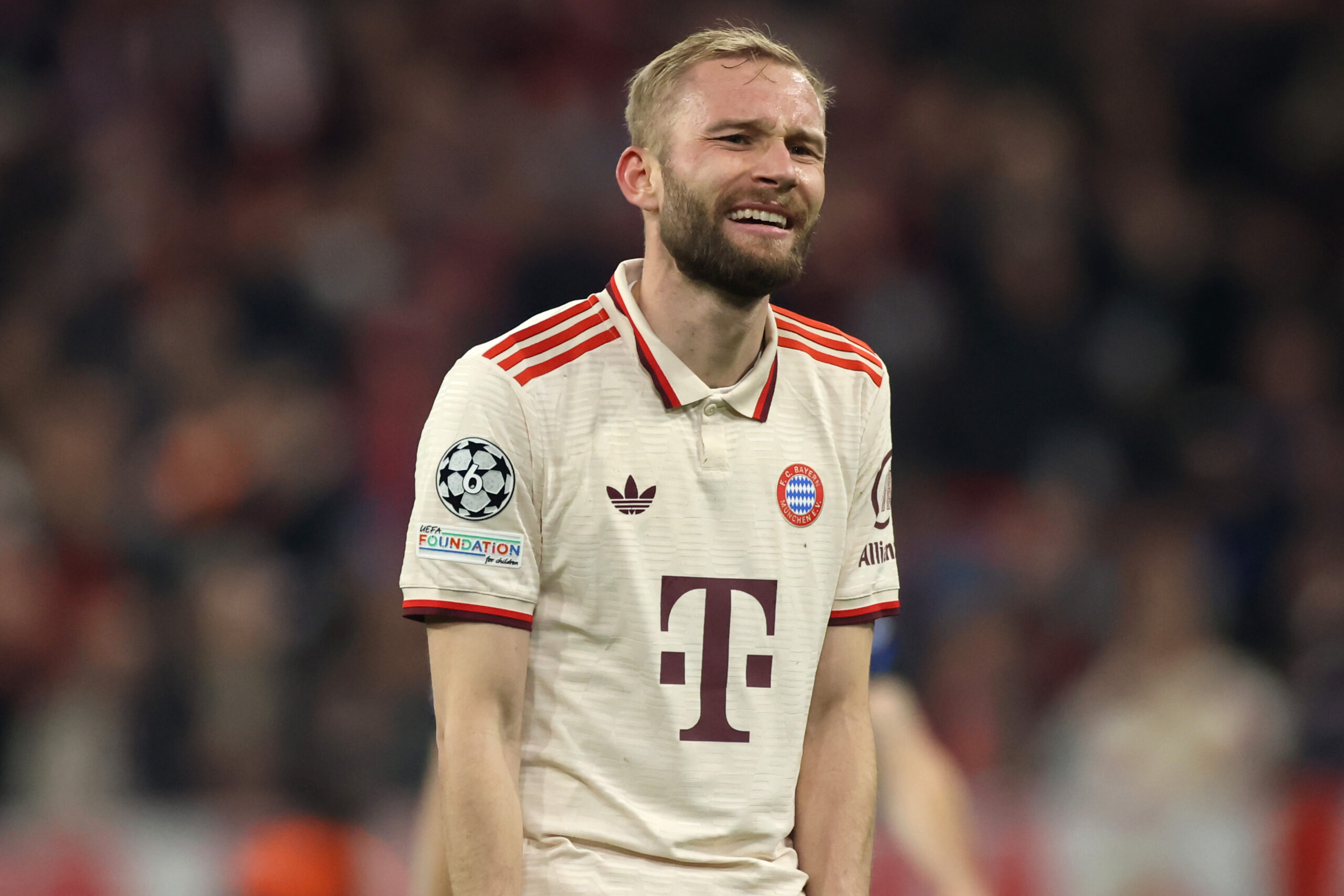 Konrad Laimer im hellen Trikot des FC Bayern und grinsend.