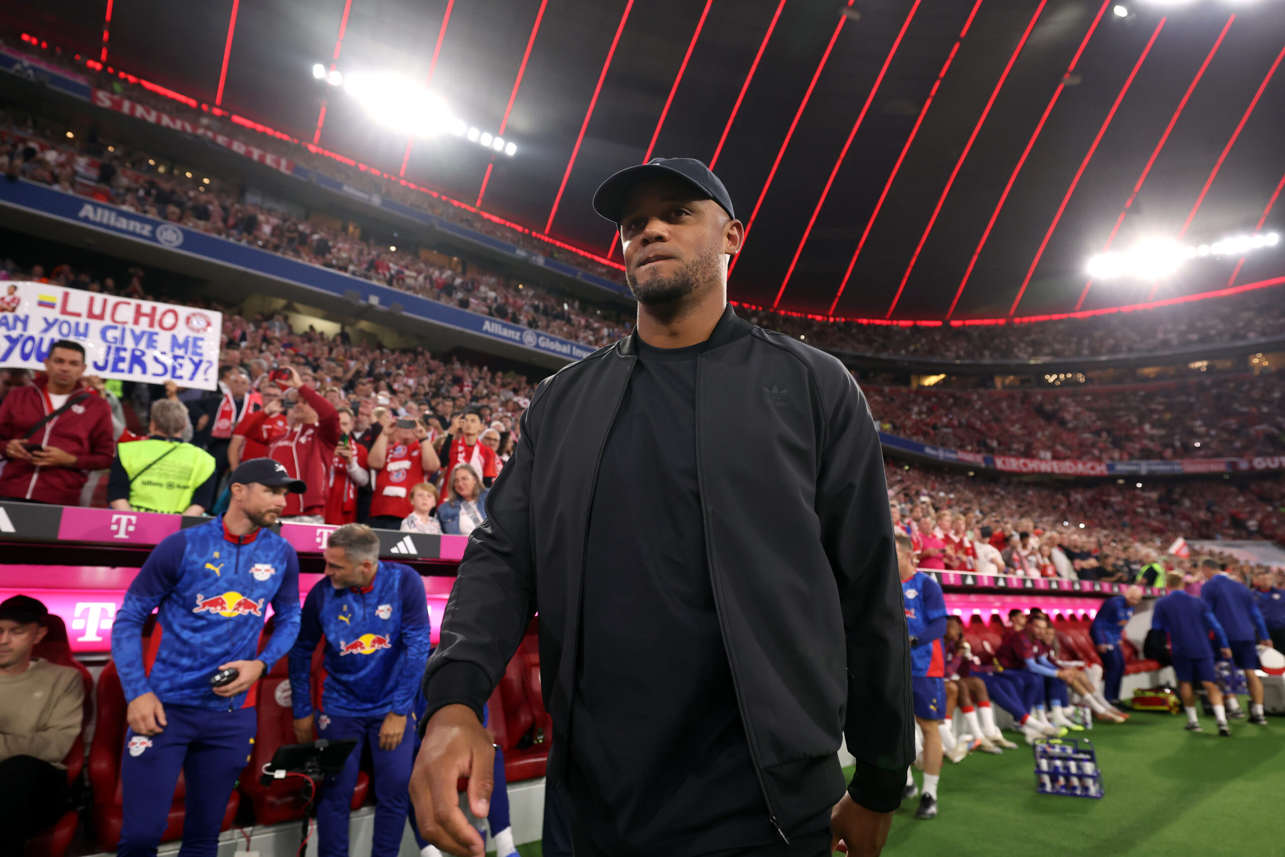 Vincent Kompany (Trainer des FC Bayern) in dunkler Kleidung. Im Hintergrund die Tribünen der Allianz Arena.