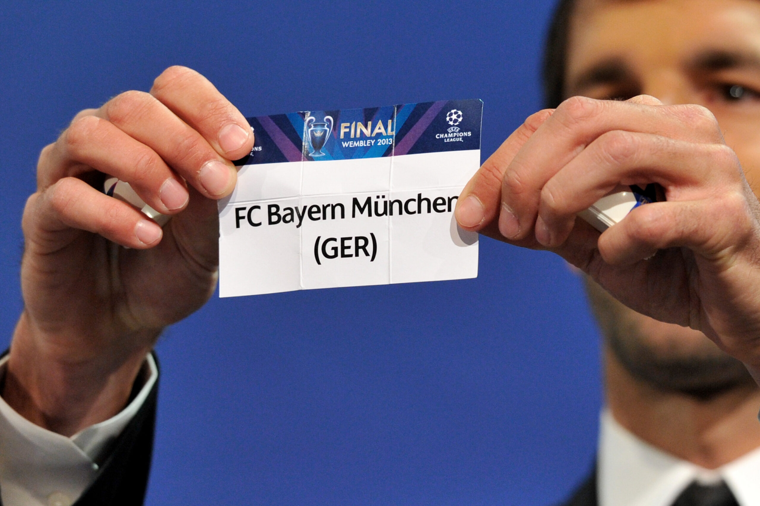Auf einem Papier steht "FC Bayern München", Ruud van Nistelrooy hält das Papier fest.