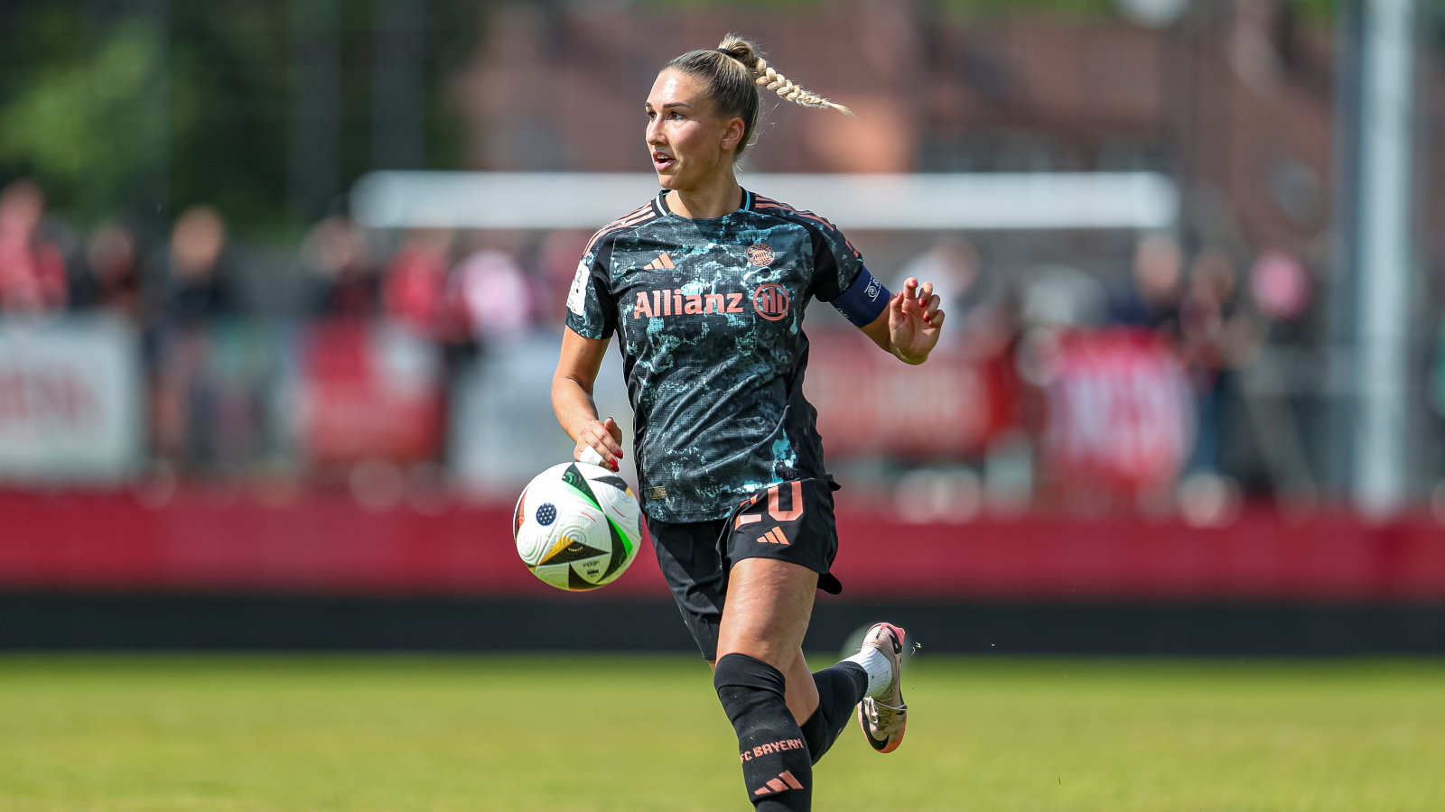 Jana Kappes im Auswärtstrikot der FC Bayern Frauen. Sie schaut nach vorn und der Ball ist vor ihr in der Luft.