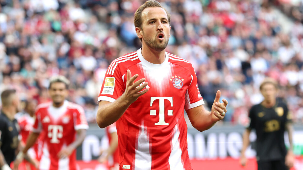 Harry Kane im rot-weißen Trikot des FC Bayern München. Er reißt den Mund etwas auf.