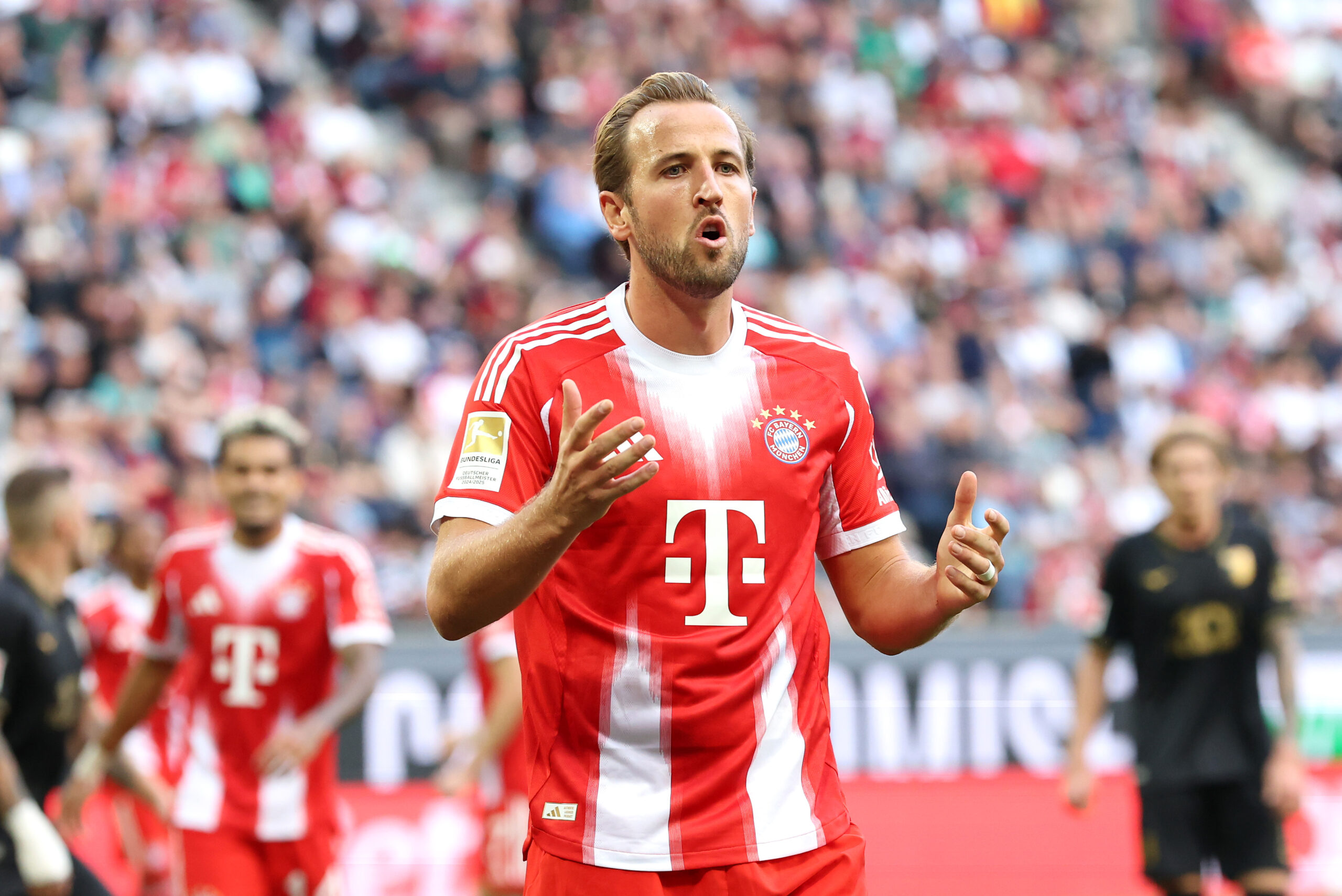 Harry Kane im rot-weißen Trikot des FC Bayern München. Er reißt den Mund etwas auf.