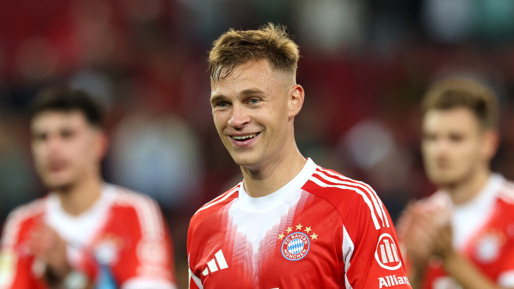 Joshua Kimmich lächelnd im rot-weißen Trikot des FC Bayern München.