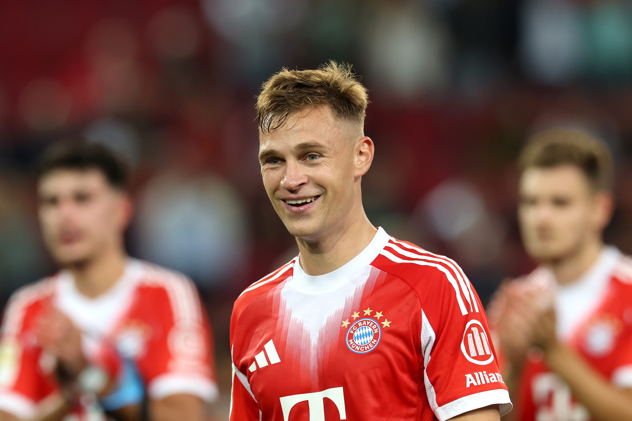 Joshua Kimmich lächelnd im rot-weißen Trikot des FC Bayern München.