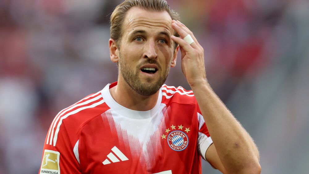 Harry Kane im Trikot des FC Bayern München. Er fässt sich an die Stirn.