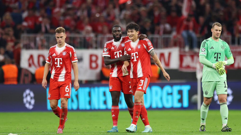 Dayot Upamecano und Min-jae Kim liegen sich nach dem Sieg des FC Bayern München gegen den FC Chelsea in den Armen.