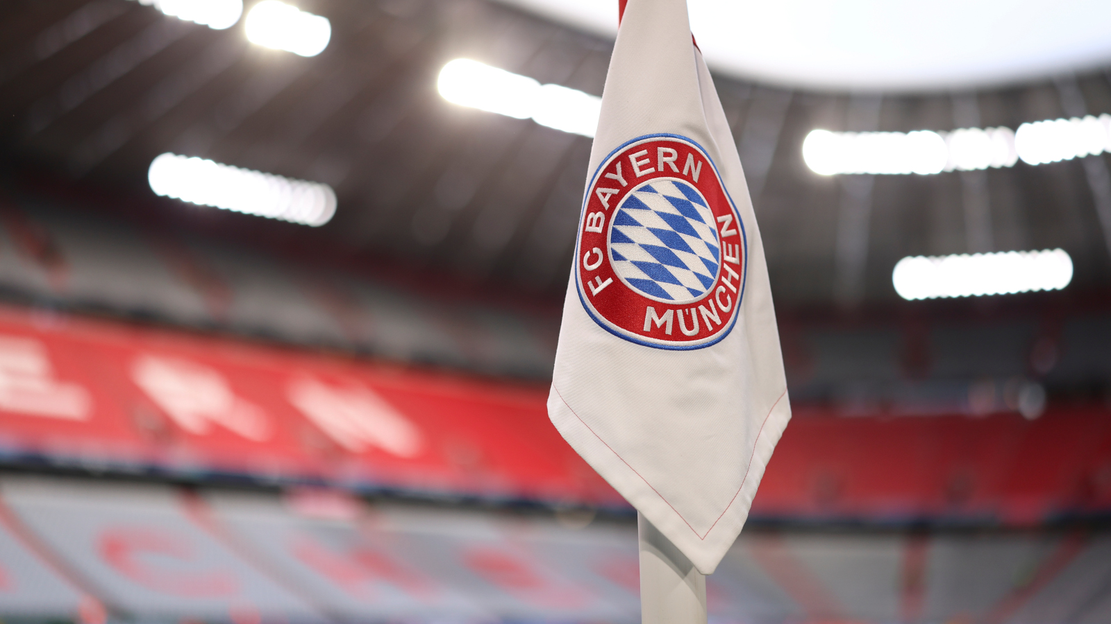 Eine Fahne in der Allianz Arena, auf der das Logo des FC Bayern München zu sehen ist.