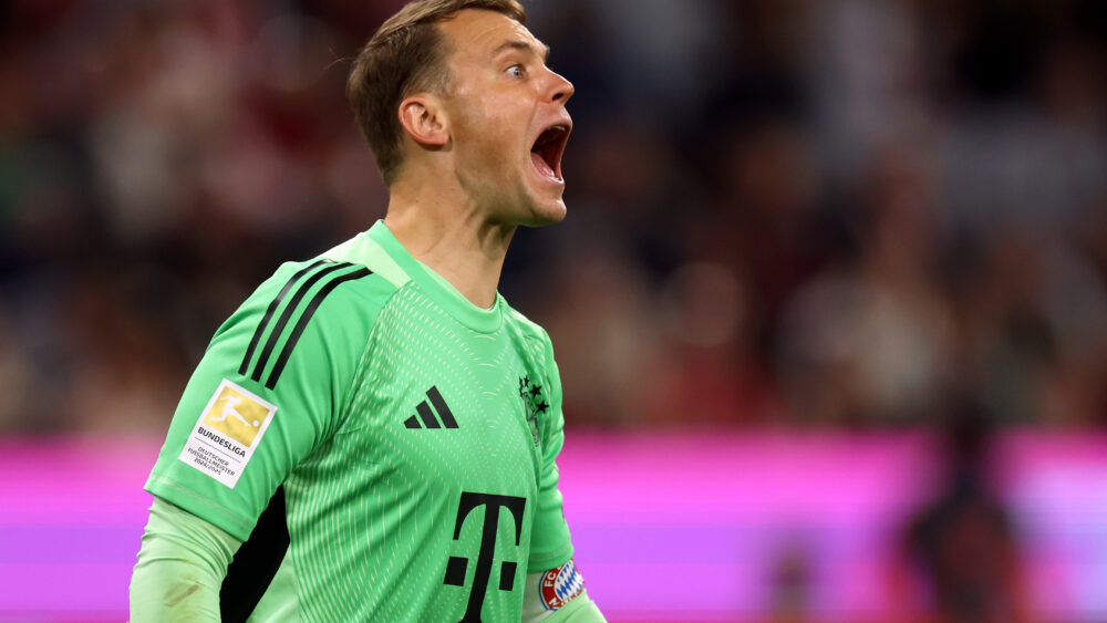 Manuel Neuer im grünen Torwarttrikot des FC Bayern. Sein Mund und seine Augen sind weit aufgerissen, sein Hals steht unter Spannung.