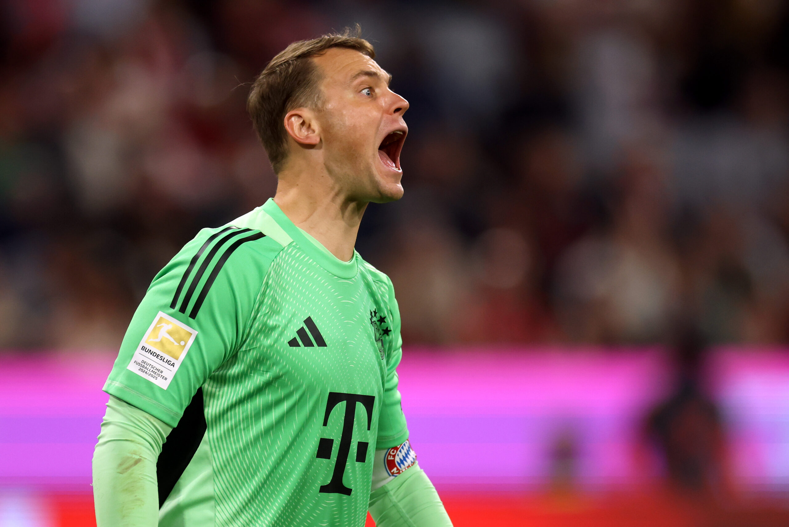 Manuel Neuer im grünen Torwarttrikot des FC Bayern. Sein Mund und seine Augen sind weit aufgerissen, sein Hals steht unter Spannung.