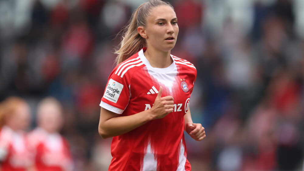 Katharina Naschenweng trägt das rot-weiße Trikot der FC Bayern Frauen und joggt offenbar.