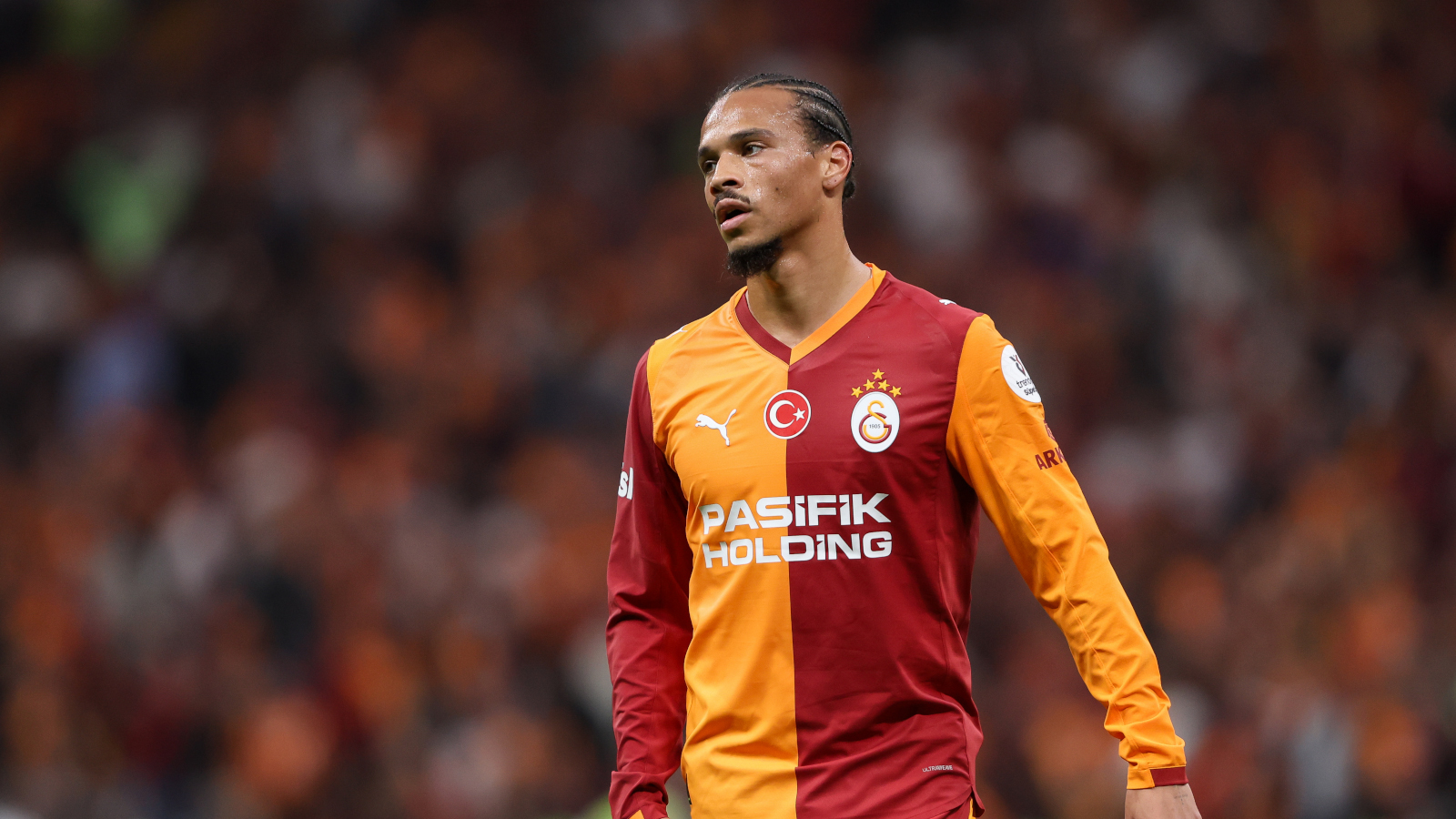 Leroy Sané hat den FC Bayern München in Richtung Galatasaray verlassen. Im Bild ist er mit enttäuschtem Blick im orange-roten Trikot der Türken zu sehen.