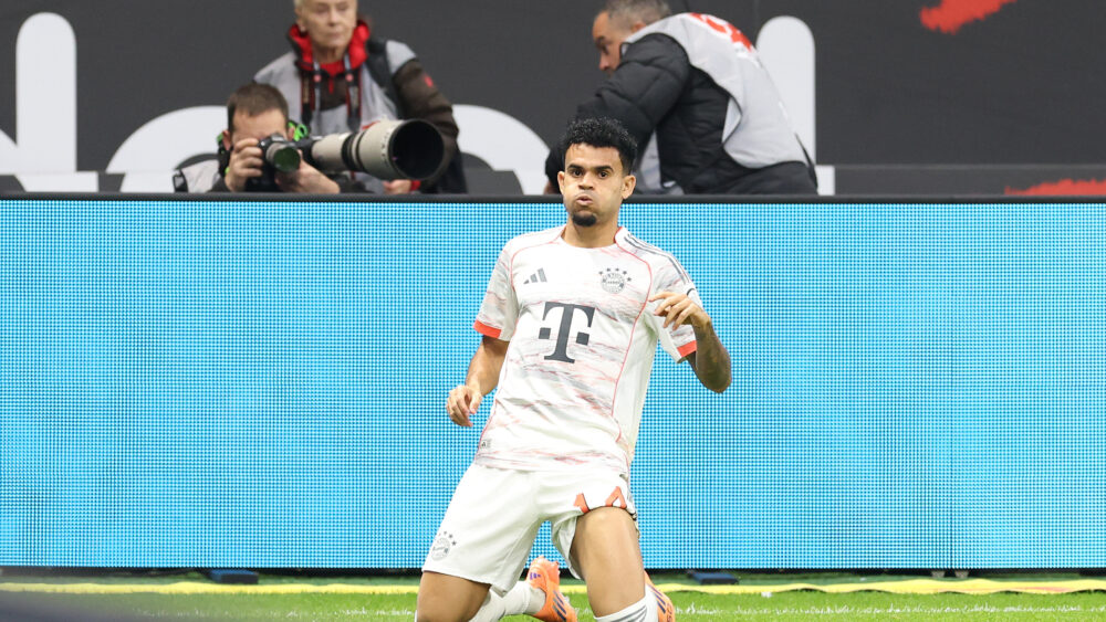 Luis Díaz auf den Knien im weißen Trikot des FC Bayern München.