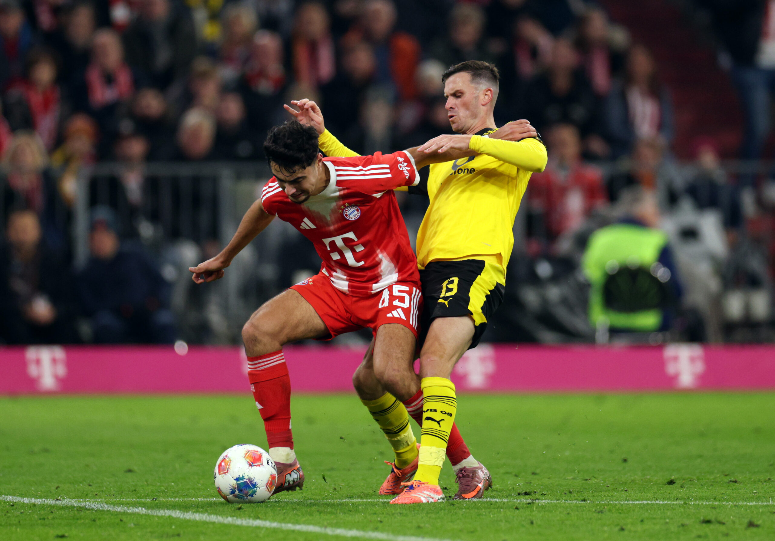Aleksandar Pavlovic vom FC Bayern München im Zweikampf mit Pascal Groß vom BVB.