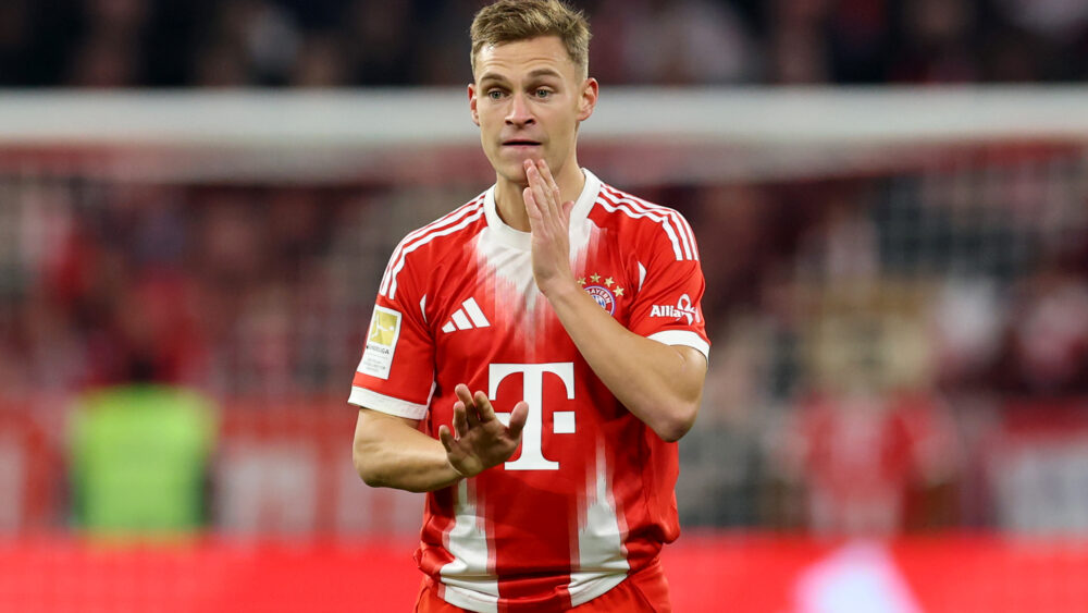 Joshua Kimmich vom FC Bayern München fässt sich ins Gesicht und schaut etwas unsicher.