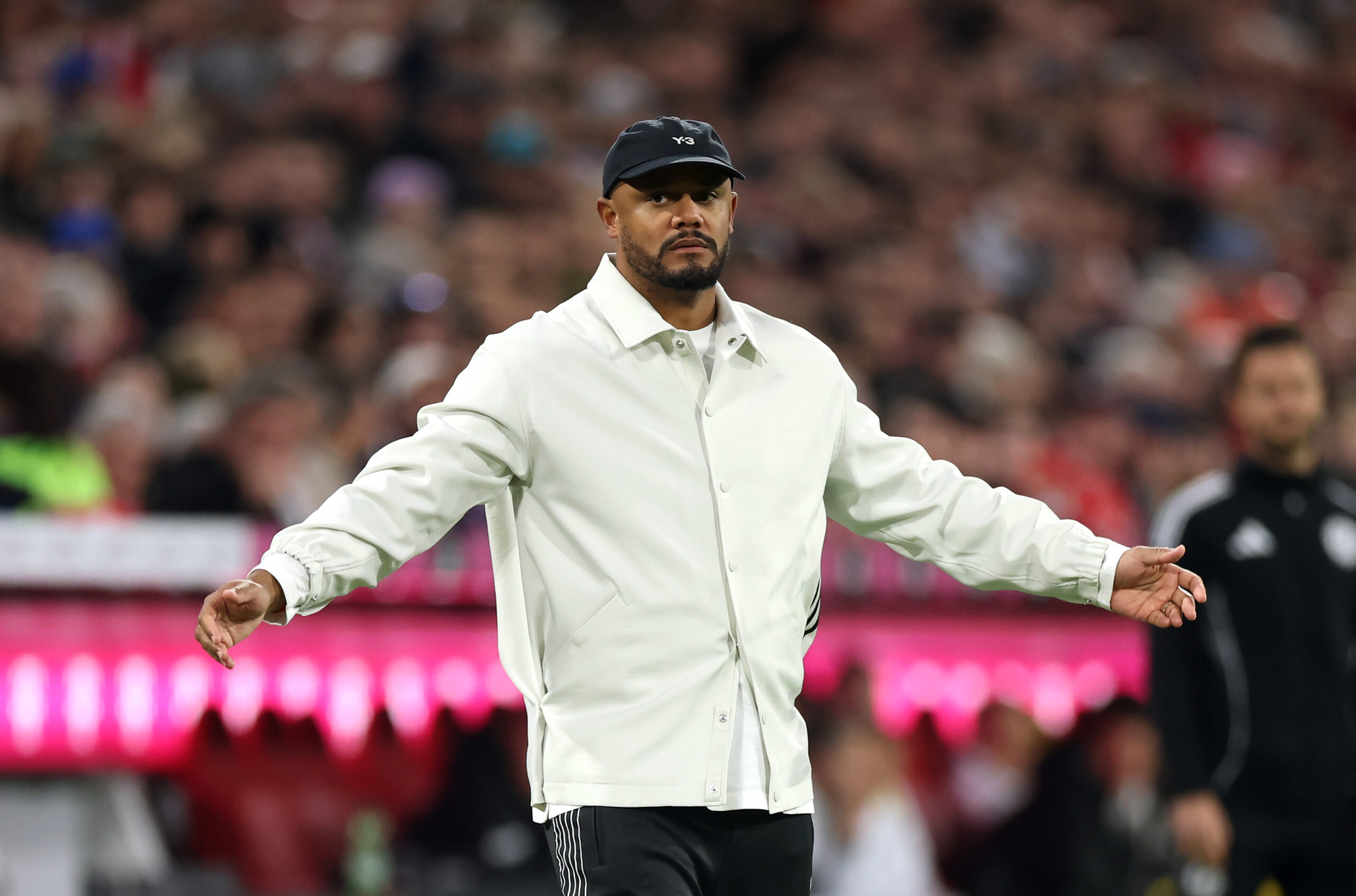 Vincent Kompany (FC Bayern) breitet die Arme aus. Im Hintergrund das Publikum in der Allianz Arena.