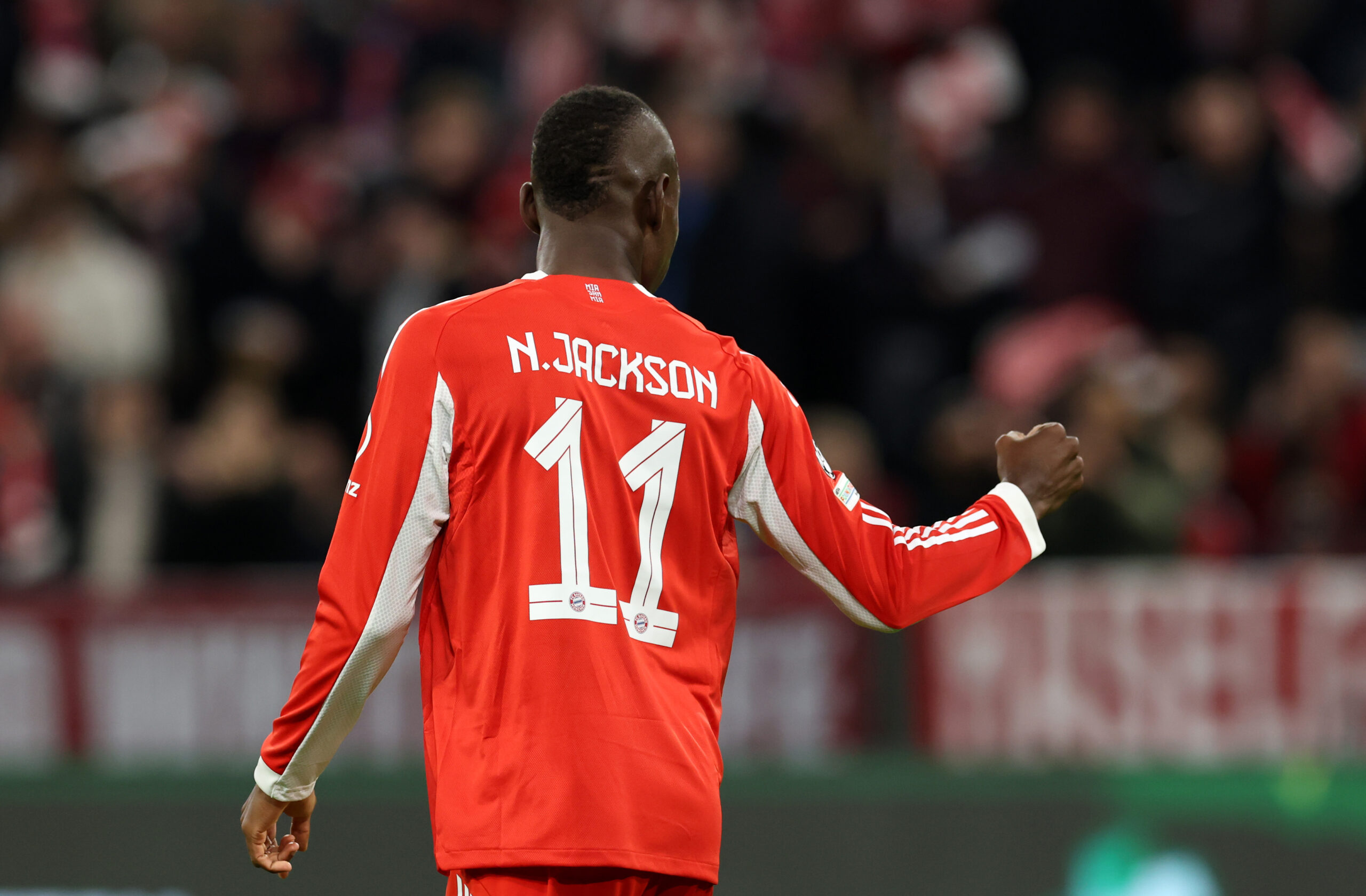 Nicolas Jackson vom FC Bayern München aus der Rückansicht. Er ballt die Faust.