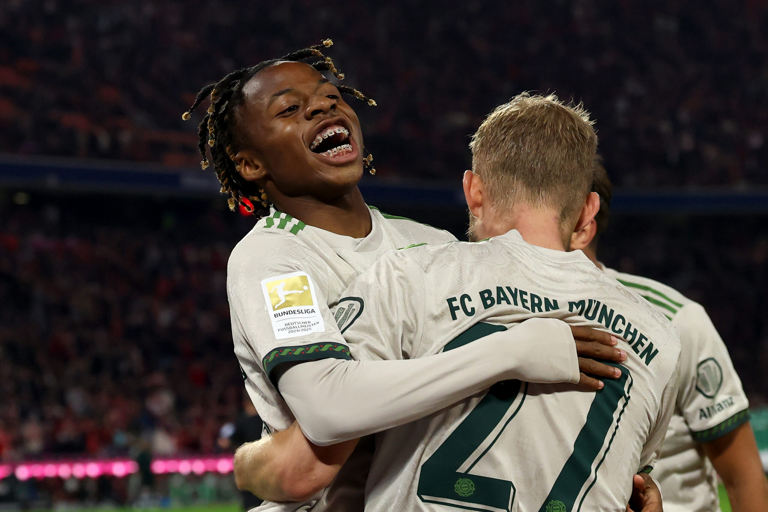 Wisdom Mike jubelt mit Konrad Laimer im Trikot des FC Bayern München.