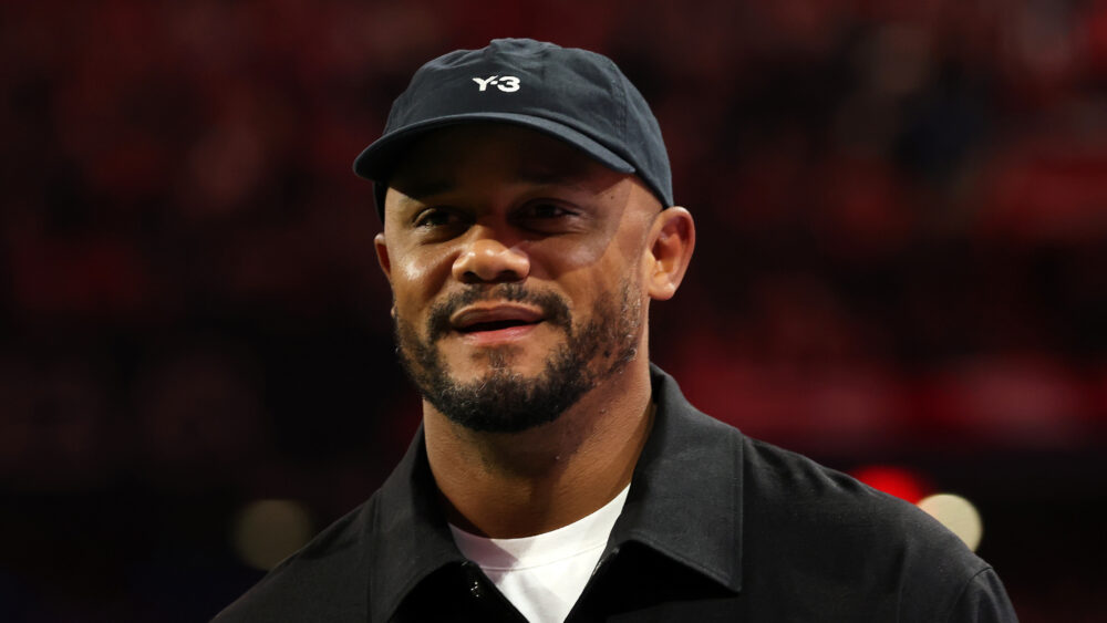 Vincent Kompany vom FC Bayern München in dunkler Kleidung und lächelnd.