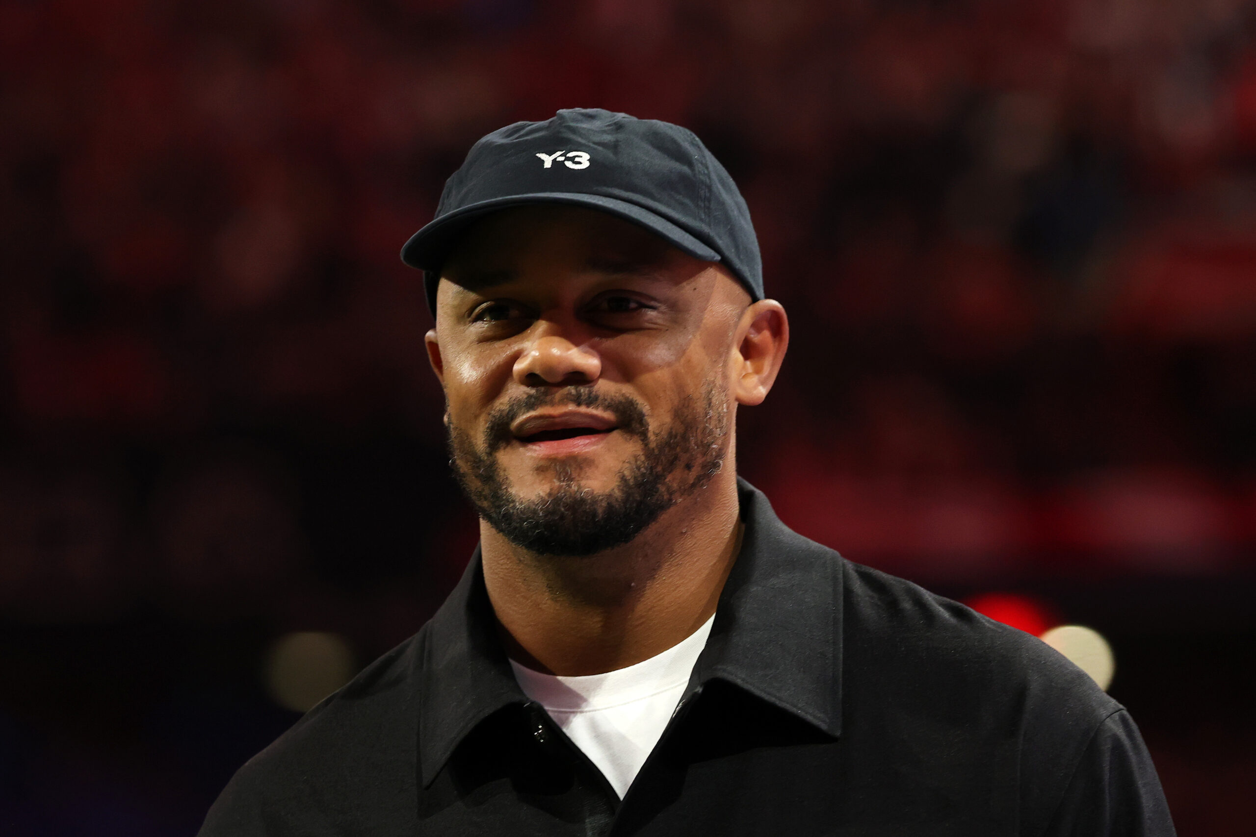 Vincent Kompany vom FC Bayern München in dunkler Kleidung und lächelnd.