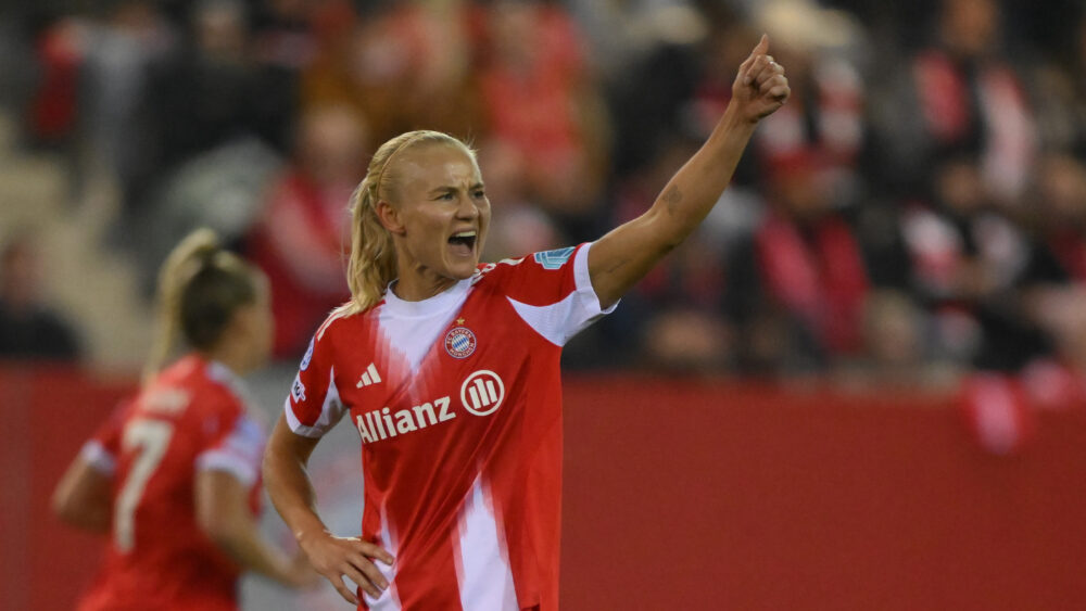 Pernille Harder (FC Bayern) hebt den linken Arm, zeigt den Daumen hoch und scheint sich zu freuen.