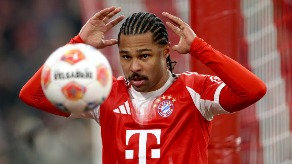 Serge Gnabry hält die Hände über dem Kopf. Er wirft offenbar den Ball, der vor ihm zu sehen ist. Er trägt ein rot-weißes Trikot des FC Bayern.