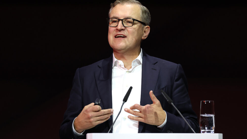 Jan-Christian Dreesen an einem Rednerpult auf der JHV des FC Bayern München.