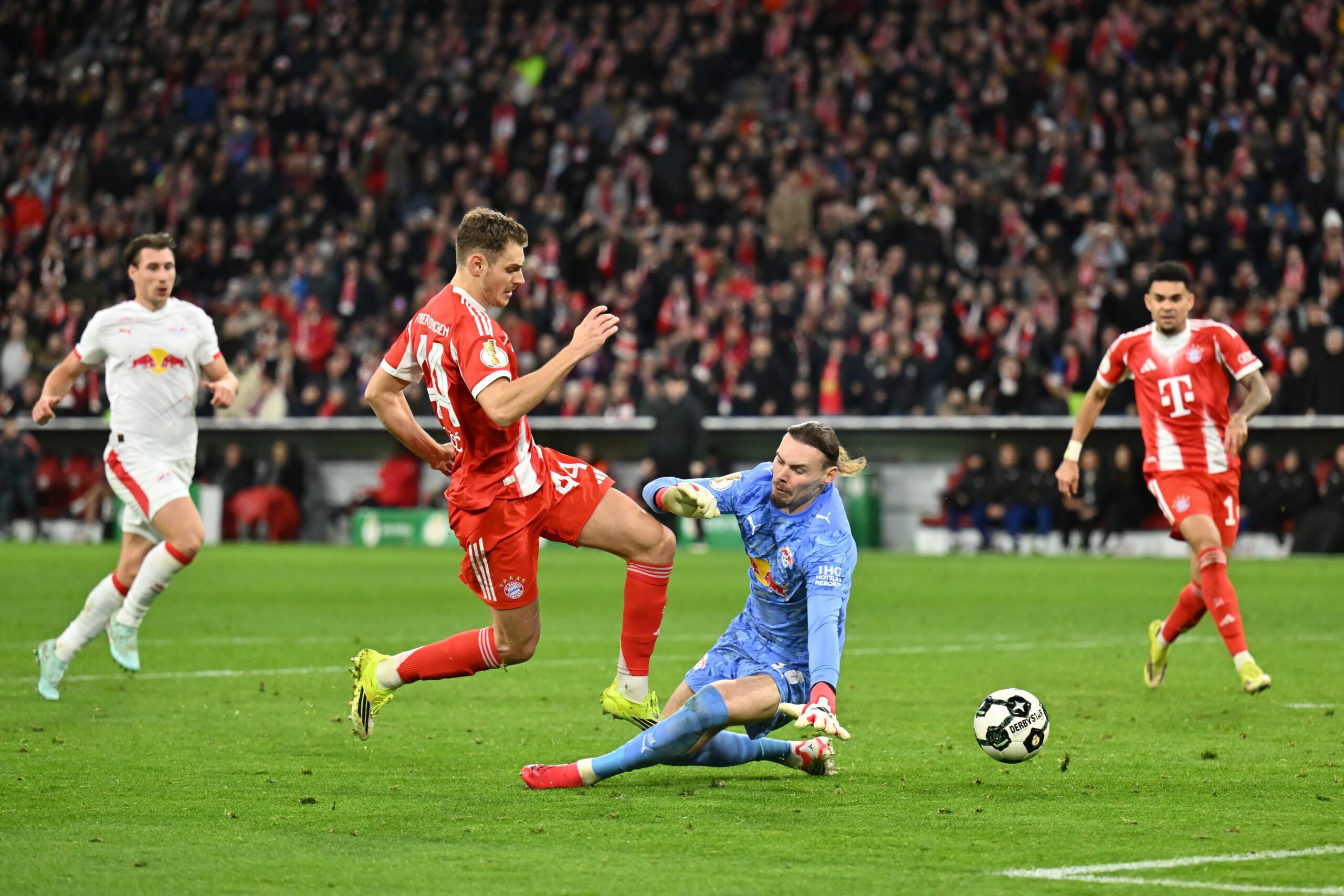 Josip Stanisic im Duell mit Vandevoordt beim Spiel zwischen dem FC Bayern und Leipzig im DFB-Pokal