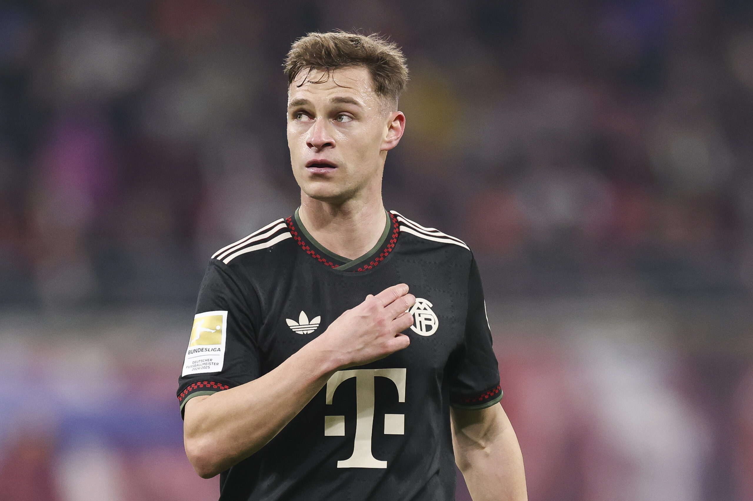 Joshua Kimmich im schwarzen Trikot des FC Bayern. Er schaut etwas besorgt.