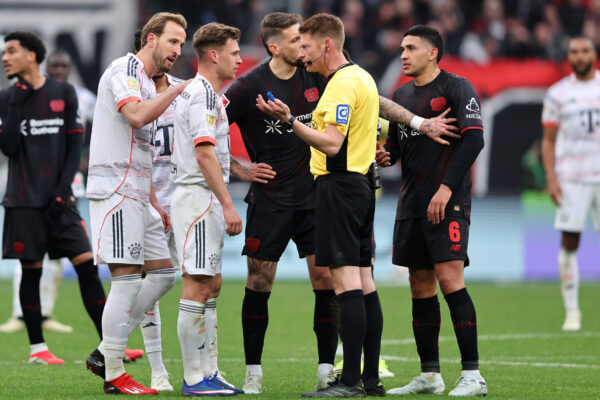 Die Spieler des FC Bayern und von Bayer Leverkusen diskutieren mit Schiedsrichter Christian Dingert.