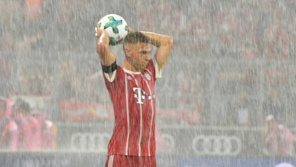 Joshua Kimmich (FC Bayern) beim Einwurf im starken Regen.