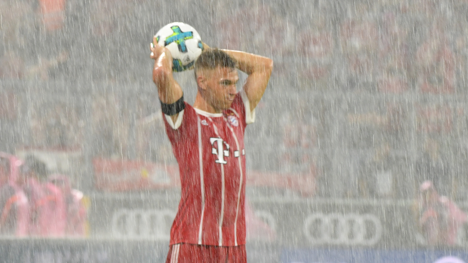 Joshua Kimmich (FC Bayern) beim Einwurf im starken Regen.
