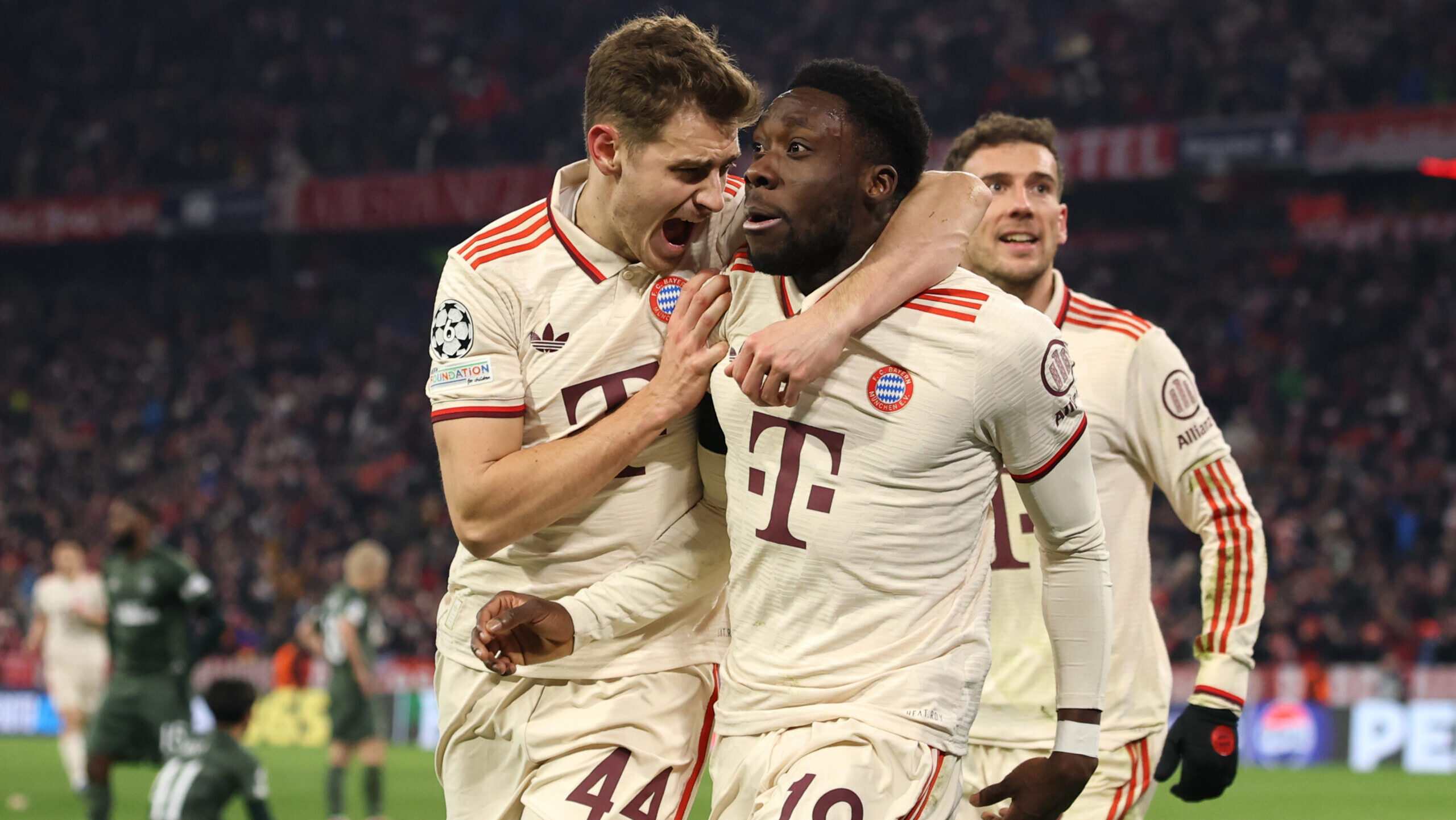 Josip Stanišić und Alphonso Davies jubeln im Trikot des FC Bayern