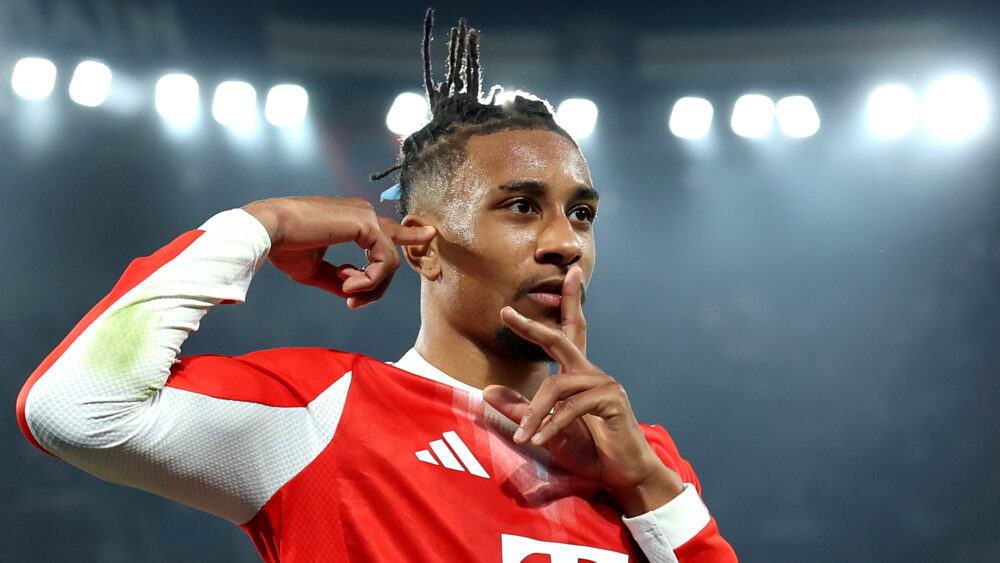 Michael Olise (FC Bayern) mit seinem Jubel, bei dem er den Finger vor den Mund hält und einen anderen Finger seitlich an die Stirn.