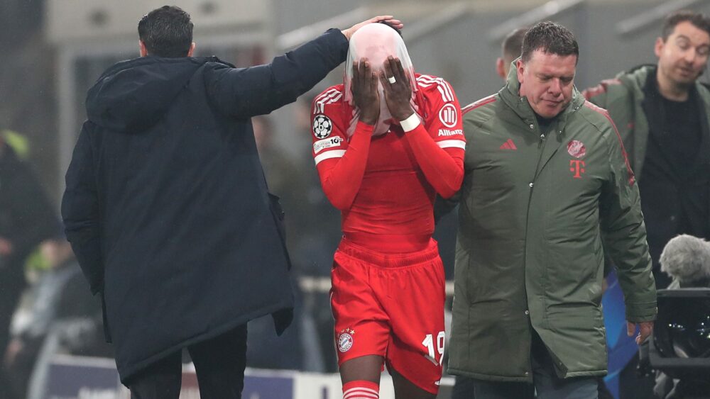 Alphonso Davies zieht sich das Trikot des FC Bayern über sein Gesicht