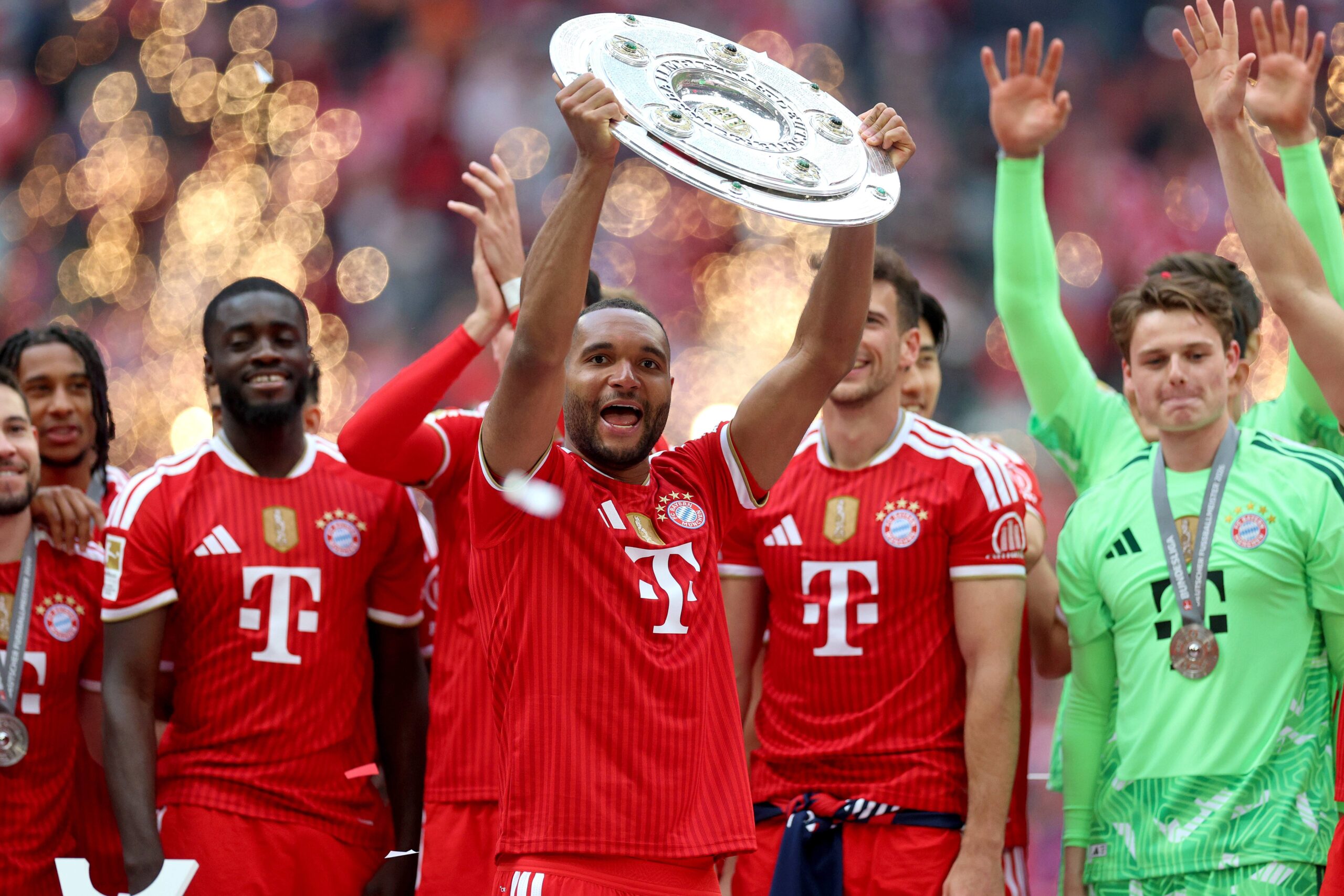 Jonathan Tah hebt die Meisterschale in die Luft, die er mit dem FC Bayern gewonnen hat.