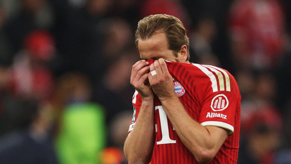 Harry Kane hält sich das Trikot des FC Bayern vors Gesicht