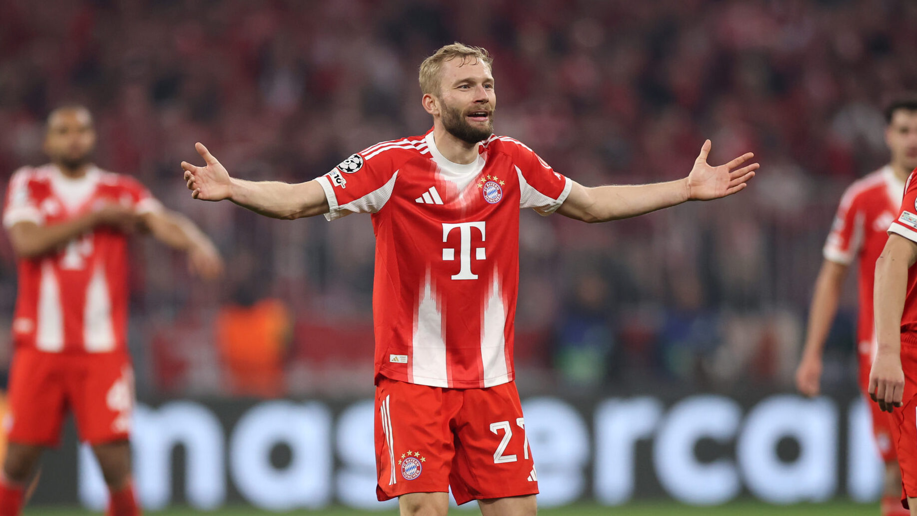 Konrad Laimer streckt die Arme fragend zur Seite aus. Er trägt das rot-weiße Trikot des FC Bayern.