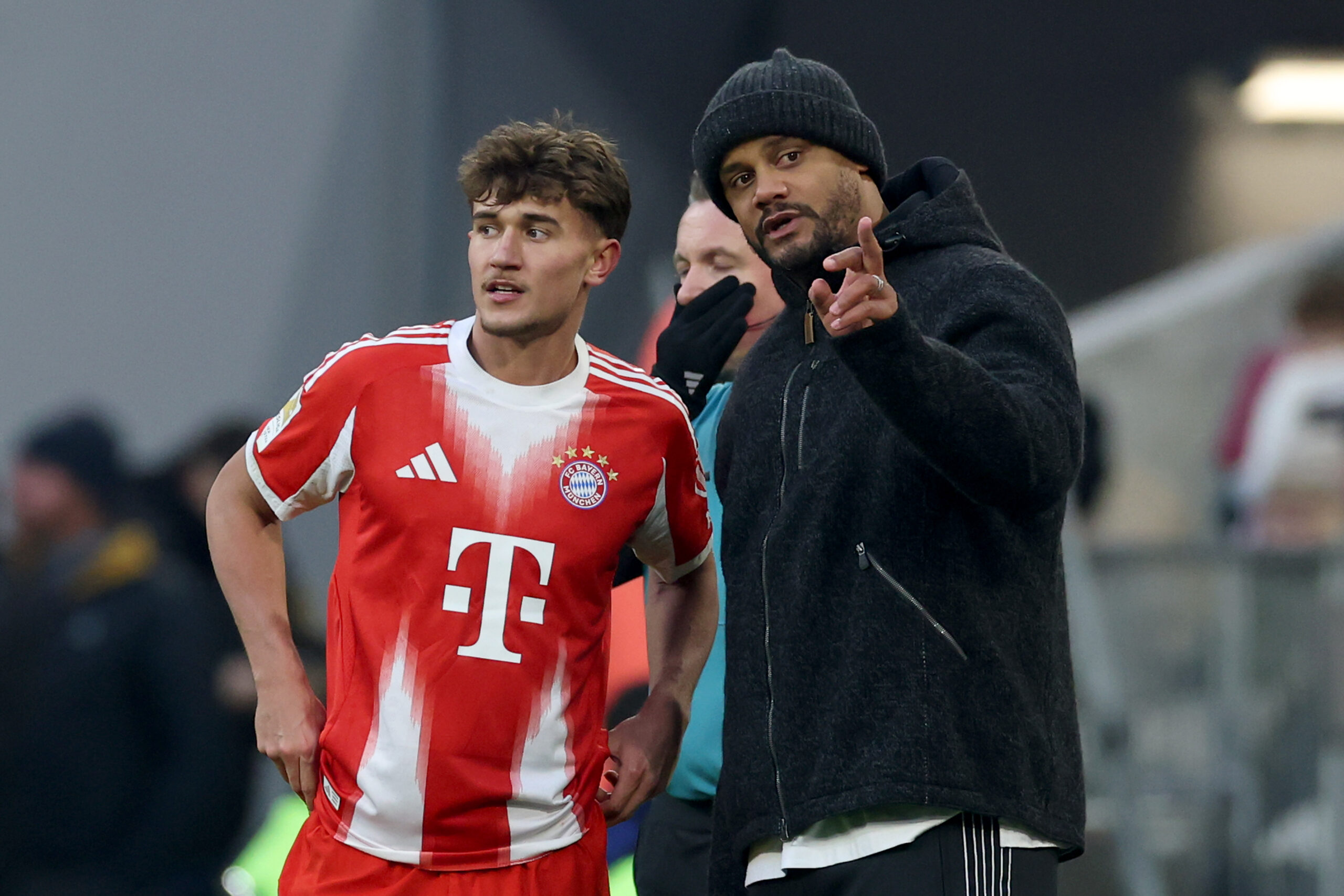 Tom Bischof und Vincent Kompany (beide FC Bayern) diskutieren etwas. Kompany zeigt dabei nach vorn.