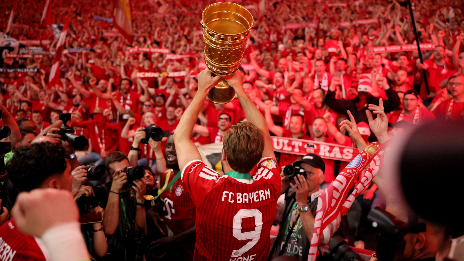 Harry Kane streckt den DFB-Pokal vor den Fans des FC Bayern in die Höhe.
