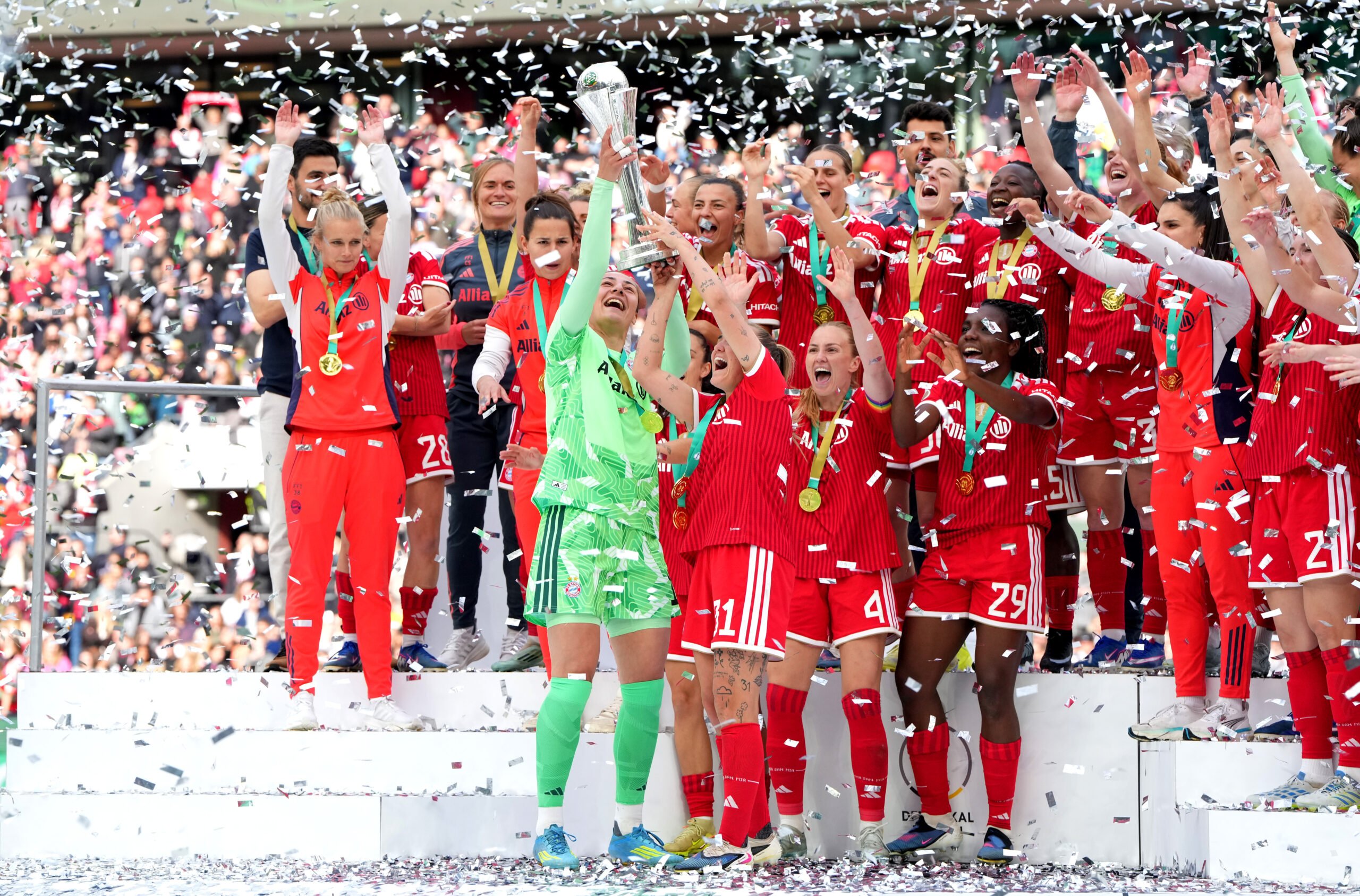 Die FC Bayern Frauen heben den DFB-Pokal nach dem Sieg gegen den VfL Wolfsburg in die Luft.