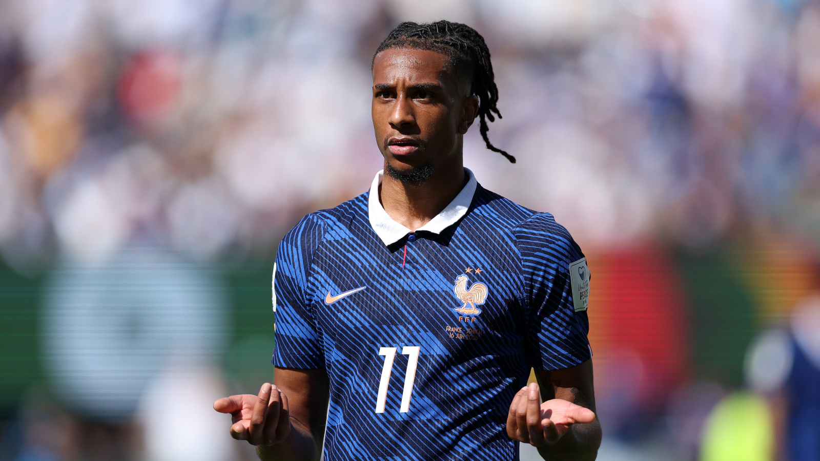 Michael Olise (FC Bayern) guckt fragend und verwundert im Frankreich-Trikot.